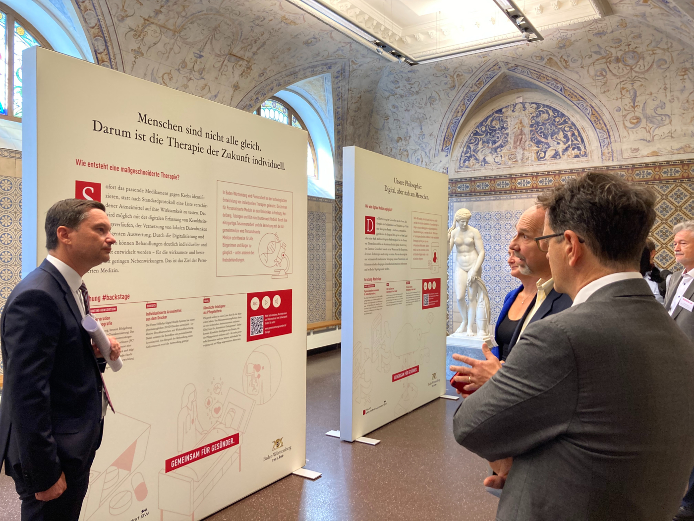 Die Wanderausstellung „Gemeinsam für Gesünder“ war in Bad Wildbad im Forum König-Karls-Bad zu Gast. MdB Klaus Mack (links) und Michael Kleiner (ganz rechts), Amtschef im Ministerium für Wirtschaft, Arbeit und Tourismus, lassen sich hier beispielhafte Modellprojekte aus dem Forum erläutern.